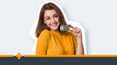 Uśmiechnięta kobieta w żółtej bluzce prezentuje dowód osobisty