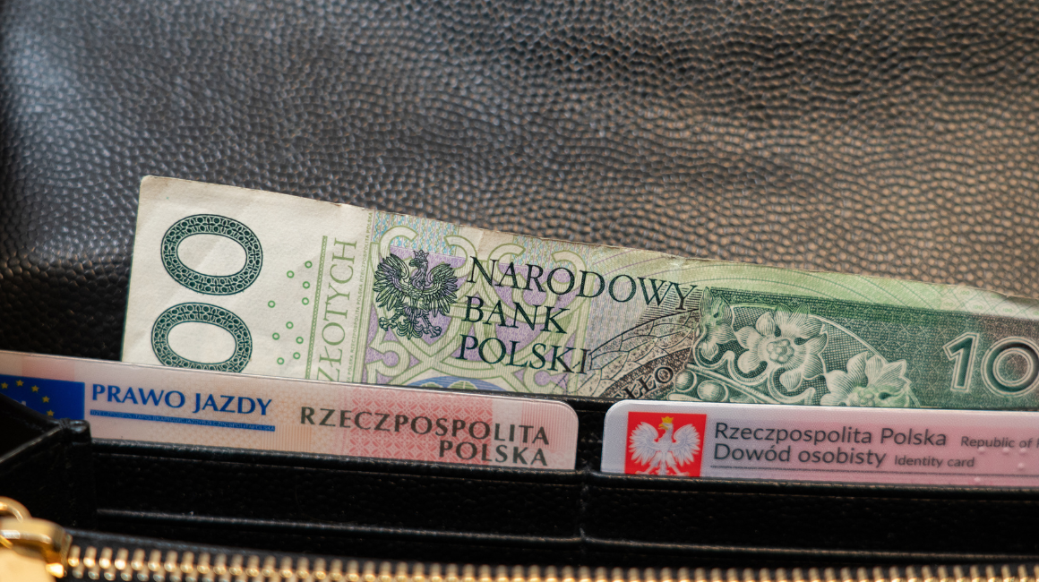Portfel z banknotem 100 zł i dokumentami: dowód osobisty oraz prawo jazdy